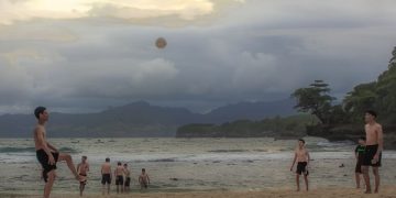 Pengunjung Pantai Coro tengah asik bermain bola di pinggir pantai. Foto: Bacaini/Setiawan