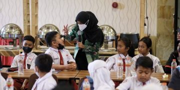 Bunda Fey berbincang dengan salah satu anak SD saat Seminar Komunikasi, Informasi dan Edukasi Keamanan Pangan. Foto: Ist