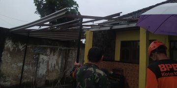 Petugas BPBD Kota Kediri melakukan penanganan di salah satu rumah warga terdampak puting beliung. Foto: Bacaini