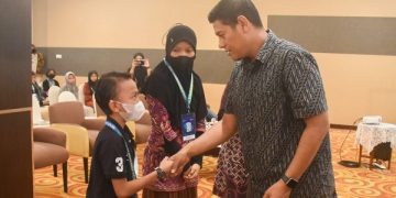Wali Kota Kediri menyalami salah satu siswa SD peserta lokakarya dan lomba lukis topeng panji. Foto: Ist