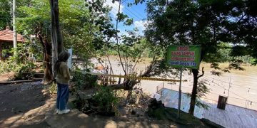 Lokasi hilangnya balita di Sungai Brantas dipasang garis polisi. Foto: Bacaini/Novira