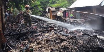 Petugas pemadam kebakaran saat melakukan pembasahan di rumah milik Khairil. Foto: Bacaini/Syailendra
