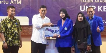Wali Kota Kediri, Abdullah Abu Bakar menyerahkan beasiswa KIP kepada salah satu mahasiswi UNP Kediri. Foto: Ist
