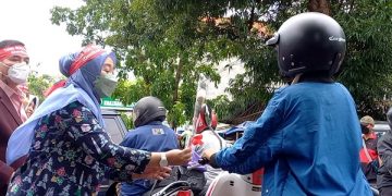 Salah satu Nakes berikan bunga pada pengguna jalan. Foto: Bacaini/Setiawan