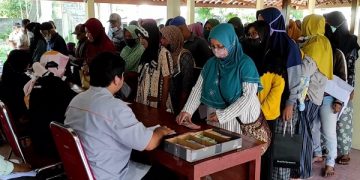 Antrean penerima bansos dari Kemensos di Balai Desa Wonojoyo. Foto: Bacaini/AK.Jatmiko