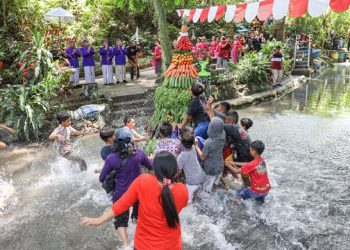 Masyarakat berebut gunungan hasil bumi yang dilarung di Sumber Banteng. Foto: Ist