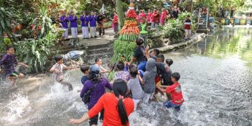 Masyarakat berebut gunungan hasil bumi yang dilarung di Sumber Banteng. Foto: Ist
