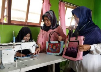 Salah satu alumni SLB Kerabat Mulia yang merupakan penyandang tuna rungu sedang menjahit. Foto: Bacaini