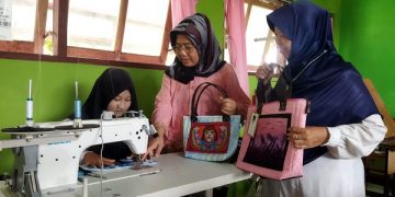 Salah satu alumni SLB Kerabat Mulia yang merupakan penyandang tuna rungu sedang menjahit. Foto: Bacaini