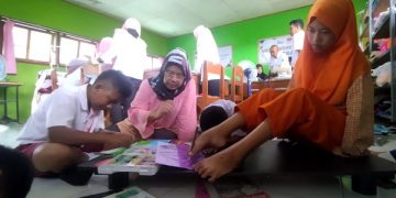 Titik Widarti saat mendampingi dan mengajari murid SLB Kerabat Mulia. Foto: Bacaini