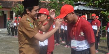 Wabup Trenggalek memakaikan topi kepada salah satu peserta diklat Bela Negara. Foto: Ist