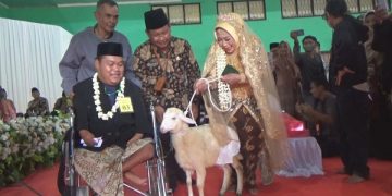 Penyerahan seekor kambing sebagai mahar pada acara nikah massal di Kantor Kemenag Kabupaten Jombang. Foto: Bacaini/Syailendra
