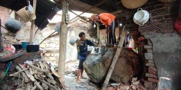 Warga berusaha memecah batu besar di dapur rumah Sumiati. Foto: Bacaini/AK.Jatmiko