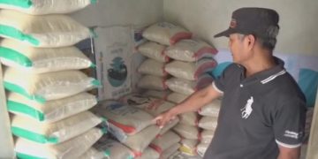 Pedagang beras menunjukkan stok beras yang tersisa di gudang. Foto: Bacaini/Syailendra