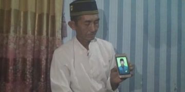 Mustain menunjukkan foto almarhum Imam Suhrowardi. Foto: Bacaini/ Syailendra
