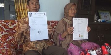 Gofur dan Ngaisah menunjukkan bukti pelunasan biaya haji. Foto: Bacaini/Syailendra
