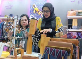 Bunda Fey menunjukkan salah satu kerajinan berbahan kayu di INACRAFT. Foto: Ist