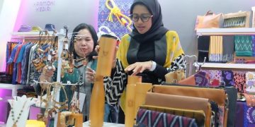 Bunda Fey menunjukkan salah satu kerajinan berbahan kayu di INACRAFT. Foto: Ist