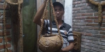 Buang menunjukkan salah satu pot bunga dari sabut kelapa berbentuk bundar hasil buatannya. Foto: Bacaini/Fio