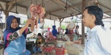 Petugas Dinas Peternakan Kabupaten Jombang di lapak pedagang daging Pasar Perak. Foto: Bacaini/Syailendra