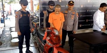 AS bersama barang bukti sepeda motor yang diamankan polisi. Foto: Bacaini/Aby