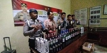 Polisi menunjukkan ratusan botol berisi miras yang berhasil diamankan. Foto: Bacaini