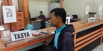 Salah satu keluarga penerima kiriman uang dari PMI di Kantor Pos Kediri. Foto: Bacaini