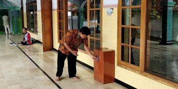 Khoiron menunjukkan gembok kotak amal yang dirusak pencuri. Foto: Bacaini/AK.Jatmiko