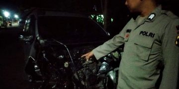 Polisi menunjukkan kondisi mobil usai tertabrak kereta api. Foto: Bacaini/AK.Jatmiko