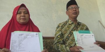 Fanani dan istri menunjukkan bukti biaya pendaftaran haji yang dilakukannya tahun 2011 silam. Foto: Bacaini/Syailendra