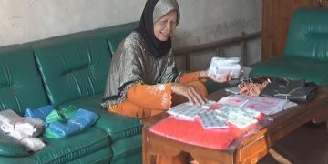 Mbah Gemi menunjukkan barang dagangan yang bisa mewujudkan tekadnya untuk pergi haji. Foto: Bacaini/Syailendra