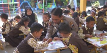 AKP Bowo mendampingi anak-anak TK saat mewarnai gambar Garuda Pancasila. Foto: Bacaini/AK.Jatmiko