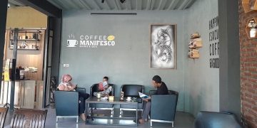 Pengunjung Kafe Manifesco yang tengah santai sambil baca buku. Foto: Bacaini/Ahmad Mustopa