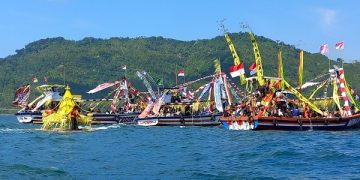 Iring-iringan perahu nelayan Pantai Prigi saat melarung tumpeng raksasa. Foto: Bacaini/Aby