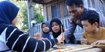 AKP Bowo memandu anak-anak SD membuat wayang sederhana berbahan kertas karton. Foto: Bacaini/AK.Jatmiko