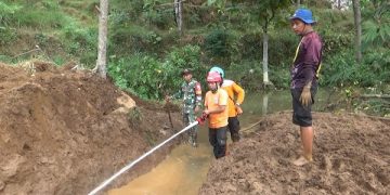 Pembersihan material longsor yang menutup aliran sungai Brogan. Foto: Bacaini/Asep Bahar