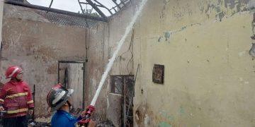 Petugas memadamkan api di rumah milik Daryanto. Foto: Bacaini/Setiawan