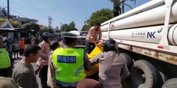 Proses evakuasi korban kecelakaan yang tewas terlindas truk. Foto: Bacaini/Asep Bahar
