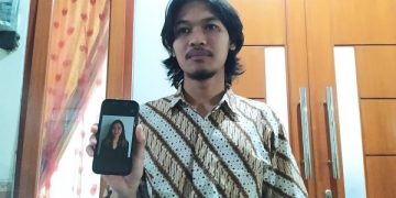 Robi menunjukkan foto Armita yang menjadi korban kecelakaan dan meninggal dunia di Australia. Foto: Bacaini/A. Ulul