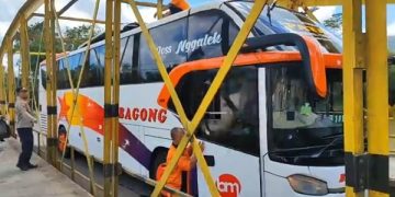 Proses evakuasi bus bagong yang tesangkut di jembatan besi. Foto: Bacaini/Aby