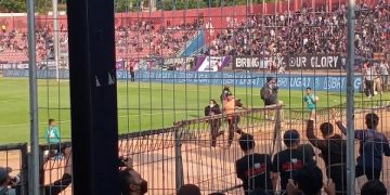 Proses evakuasi salah satu penonton perempuan yang diduga Aremania. Foto: Bacaini/Novira