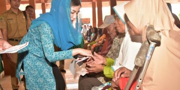 Novita Hardini saat mendampingi penyaluran bantuan PKH di Balai Desa Gandusari. Foto: Ist
