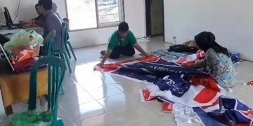 Para pekerja di rumah produksi milik Nadhiroh tengah sibuk menggarap pesanan umbul-umbul. Foto: Bacaini/Zen