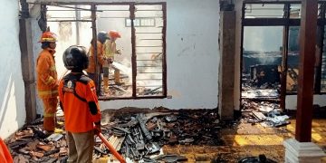 Petugas pemadam kebakaran melakukan pembasahan memastikan api benar-benar padam. Foto: Bacaini/Syailendra