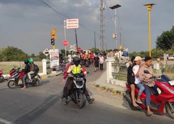 Perlintasan KA tanpa palang pintu  yang menjadi lokasi insiden naas dikerumuni warga. Foto: Bacaini/Syailendra
