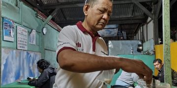Sutris saat meracik ronde petruk untuk pelangggan di warungnya. Foto: Bacaini/Setiawan