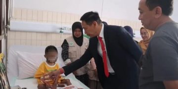 Pj Wali Kota Malang Wahyu Hidayat saat mengunjungi bocah 7 tahun korban penyiksaan keluarga. Saat ini si bocah masih dirawat di RSSA Malang. (Foto: Pemkot Malang)