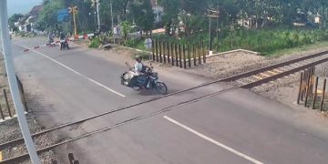 Pengendara motor yang menerobos palang pintu kereta api. Foto: SS video