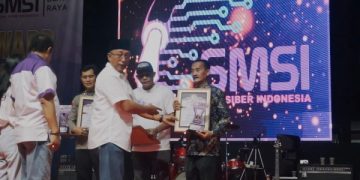 Ketua SMSI Jatim, Sokip menyerahkan penghargaan untuk eks Wabup Blitar, Rahmat Santoso diwakili politisi PAN, Sutrisno Lede, Sabtu (24/5/2025) malam (foto/ist)