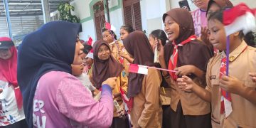 Ketua TP PKK Ghyta Eka Puspita saat membagikan cokelat untuk anak-anak pramuka di depan stasiun Jember